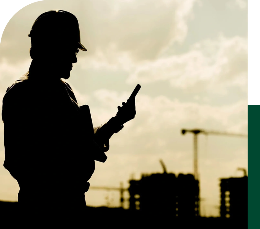 A man in hard hat holding up his cell phone.