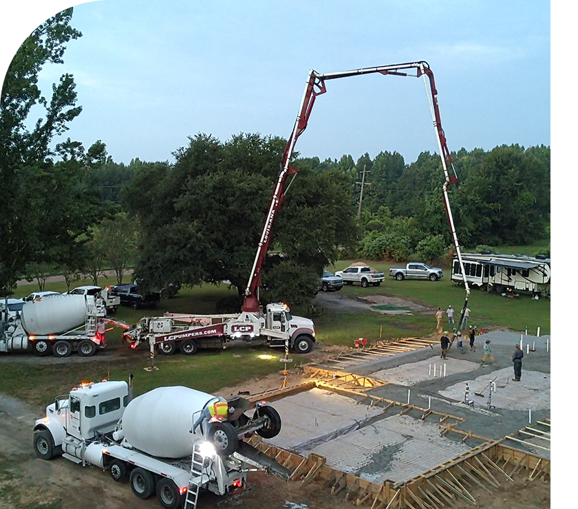 A group of people standing around a cement pile.