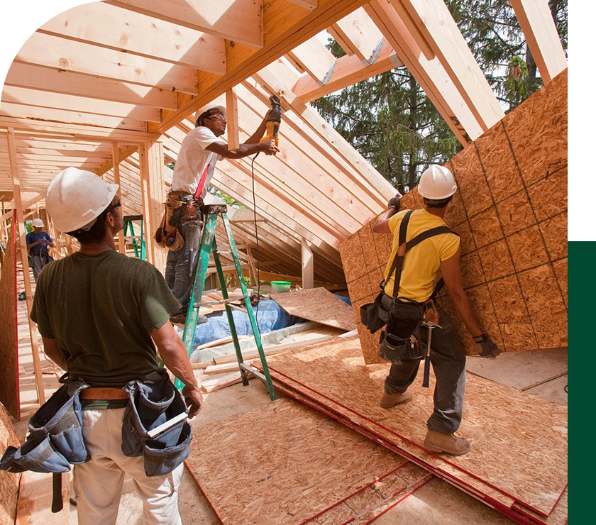 A group of men working on the roof of a house.