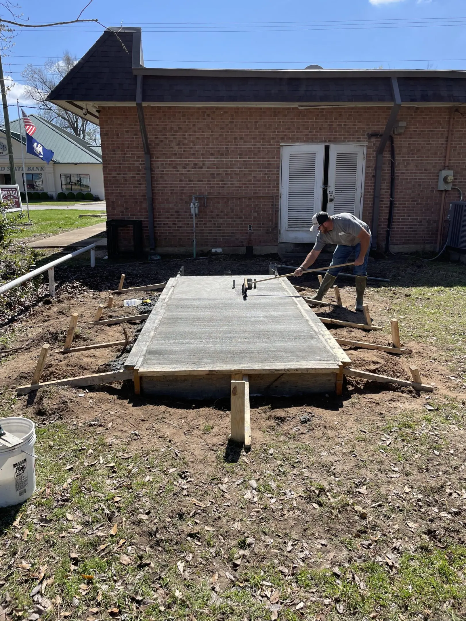 A man working on the ground in front of a house.