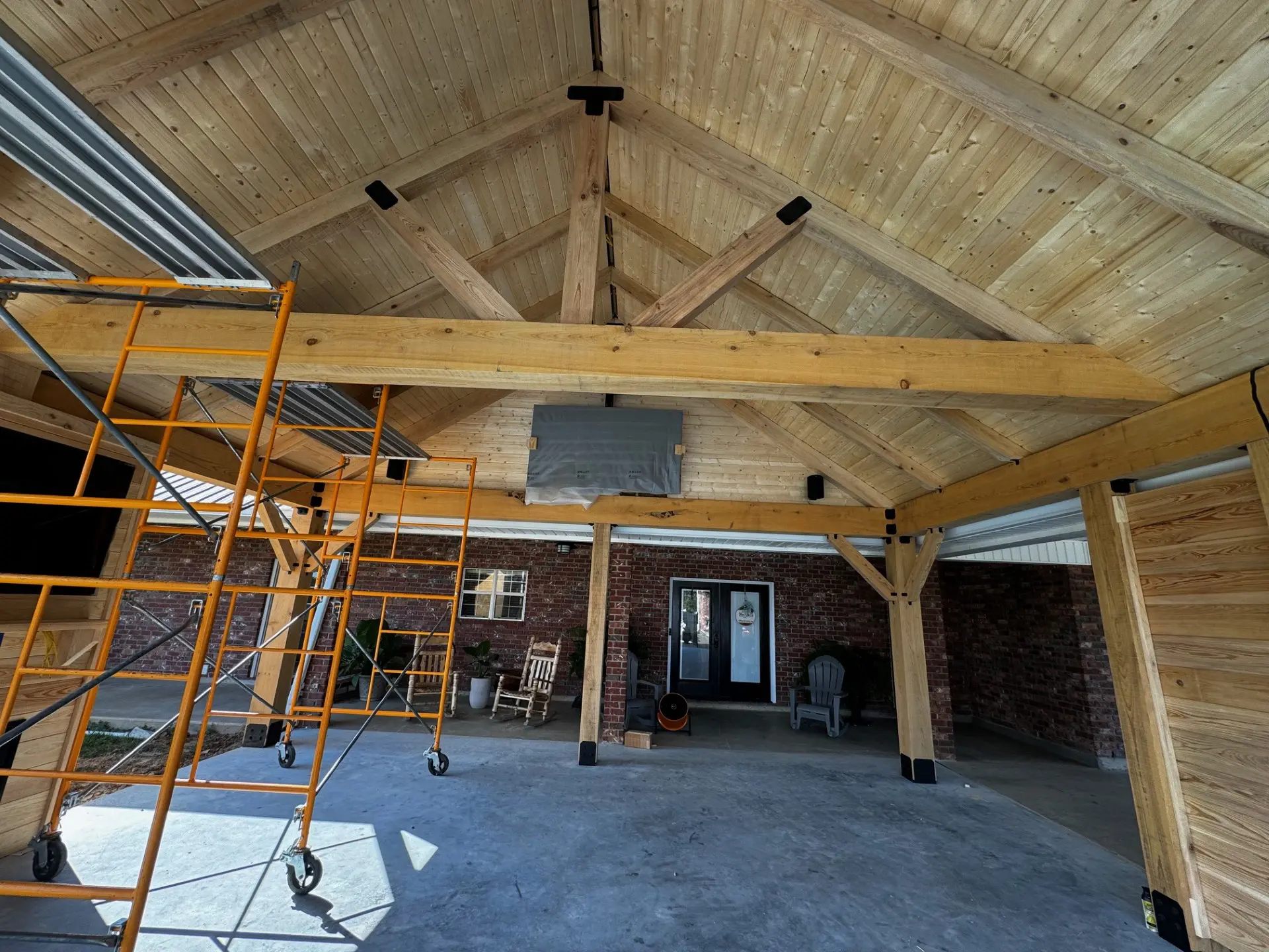 A room with a ladder and some wood beams