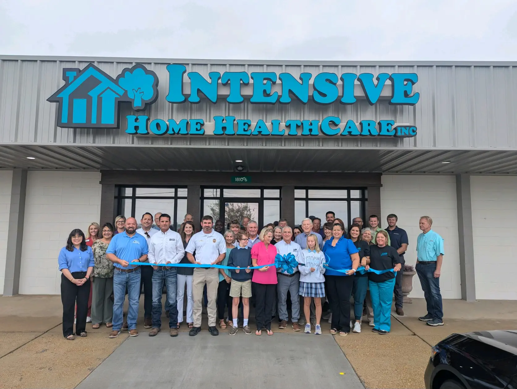 A group of people standing in front of an intensive home healthcare building.